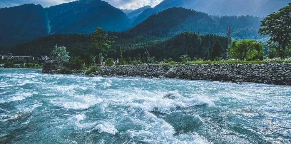 Scenic view of Lidder River flowing through lush mountains of Pahalgam Kashmir under dramatic skies